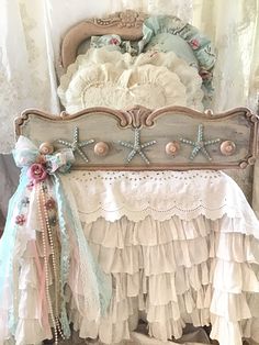 an old fashioned crib with ruffled bedspread and bows on the bottom