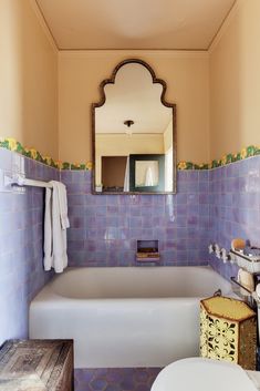 a bath tub sitting under a bathroom mirror