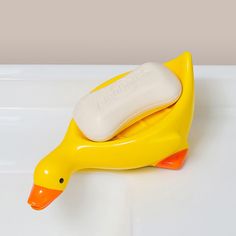 a yellow duck shaped soap dispenser on a white surface