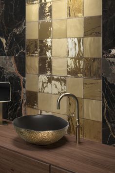 a bowl shaped sink sitting on top of a wooden counter next to a tiled wall