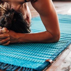 a man is doing yoga on a mat with his hands in the air and head down