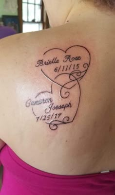 the back of a woman's shoulder with her name and two hearts tattooed on it