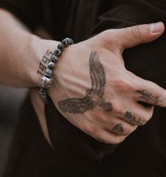 a man's arm with an eagle tattoo on it and his hand in the air