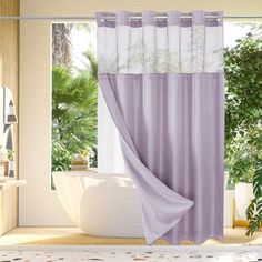 a bathroom with a bathtub, shower curtain and potted plants on the window sill