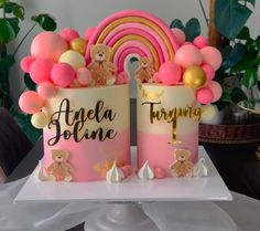 two pink and gold birthday cakes with teddy bears on the top one has a rainbow