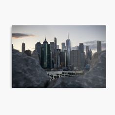 the city skyline is seen through some rocks