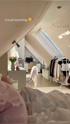 an attic bedroom is shown with clothes hanging on the rack and other items in the room