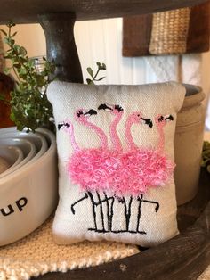 a pillow that is on top of a table next to a potted plant and some other items