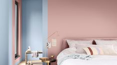 a bedroom with pink and blue walls in the corner