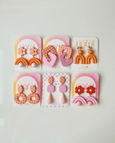 four pairs of earrings are displayed on a white surface with pink, orange and yellow accents