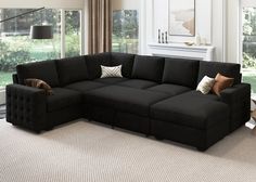 a living room with a large black sectional couch and two pillows on the back of it