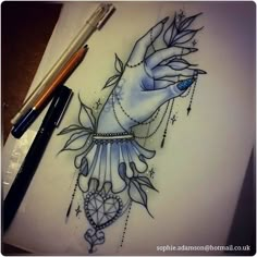 a drawing of a hand holding a heart with beads and leaves on it, next to some pens