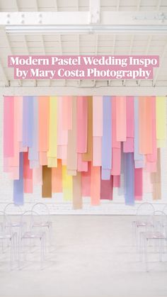 chairs are lined up in front of a wall with multicolored paper hanging from it