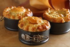 three pot pies sitting on top of a wooden table