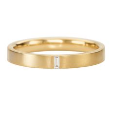 a yellow gold wedding band with a baguette cut diamond