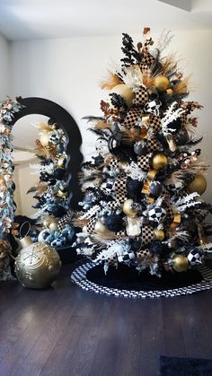 a decorated christmas tree sitting on top of a hard wood floor next to a mirror