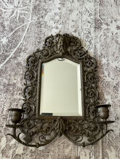 an ornate mirror is hanging on the wall