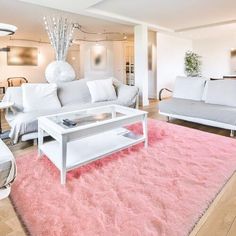 a living room filled with white furniture and pink rug