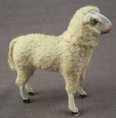 a toy sheep standing on top of a gray floor