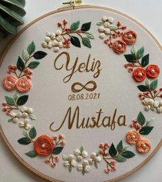 a white embroidered hoop with flowers and the words dillara meut on it