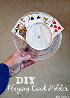 a hand holding a plastic playing card holder with four cards in it and the text diy playing card holder