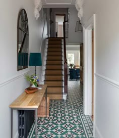 an image of a hallway with stairs and tile flooring on the bottom right hand side