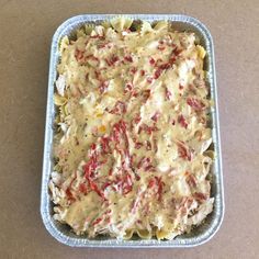 a casserole dish filled with pasta and meat in a blue pan on a table