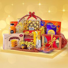 a gift hamper filled with treats and condiments on a gold colored background