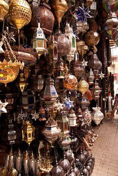 many different colored lamps are hanging on the wall