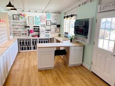 the inside of a home office with lots of clutter on the desk and shelves