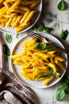 two plates filled with pasta on top of a table