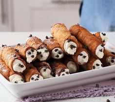 a white plate topped with croissants covered in frosting and chocolate chips