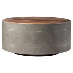 a round wooden table sitting on top of a white floor next to a metal container