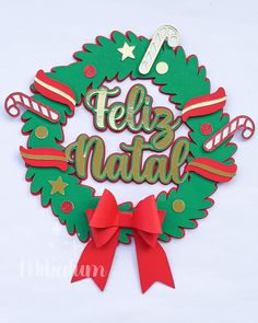 a christmas wreath with the words feliz natal on it and a red bow