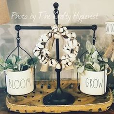 two white planters sitting on top of a wooden tray next to a sign that says bloom and grow