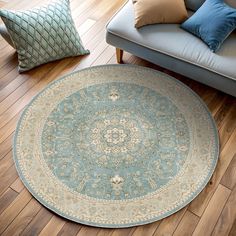 a living room with a couch, chair and round rug on the floor in front of it