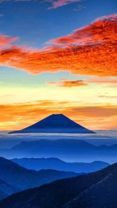 an orange and blue sunset over the mountains