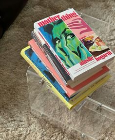 a stack of books sitting on top of a clear table