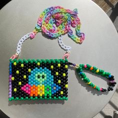 a colorful beaded purse sitting on top of a table