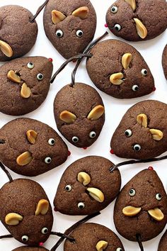 chocolate cookies with googly eyes are arranged on a white surface