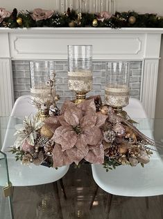 a centerpiece with candles and flowers on a table in front of a fire place