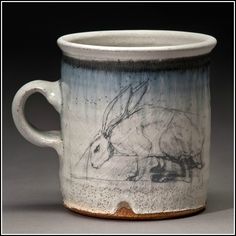 a ceramic mug with a drawing of a rabbit on it's side and inside