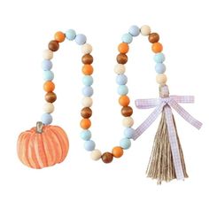 a wooden beaded necklace with an orange and white pumpkin on the front, next to it