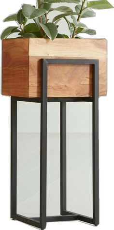 a planter that is sitting on top of a wooden table with metal legs and a mirror behind it