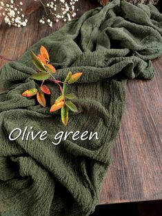 an olive green scarf on a wooden table