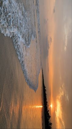 an aerial view of the ocean and beach at sunset