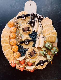 a plate filled with halloween themed cookies and candies on top of a black table