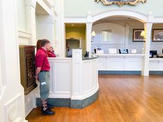 a man standing at the front desk of a hotel