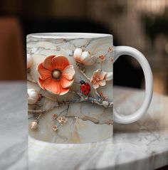 a coffee mug with an orange flower and ladybug on it sitting on a marble table