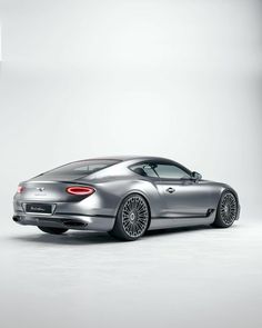 the rear end of a silver sports car on a white background with an empty area